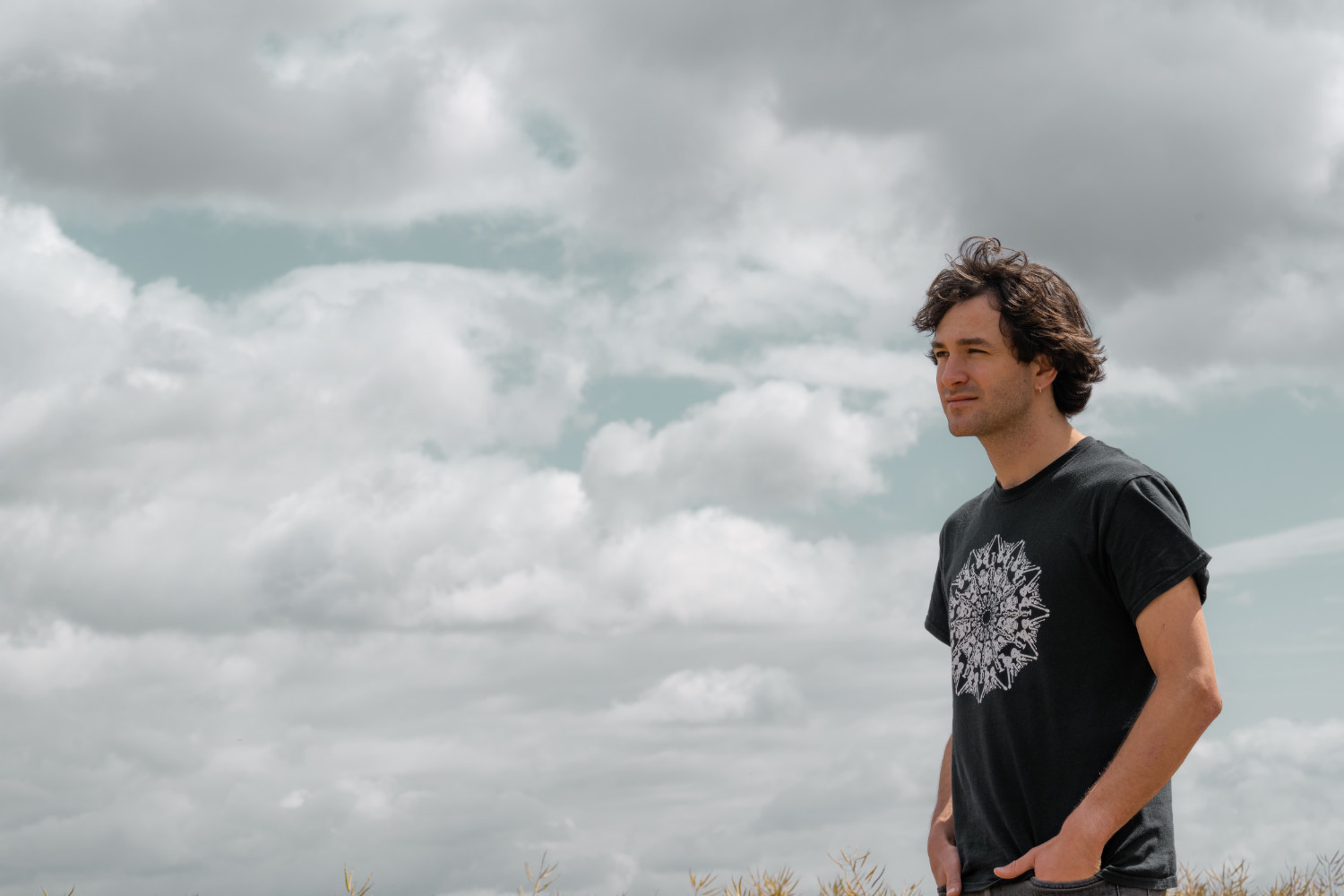 Portrait photo of Rob with grey clouds behind.